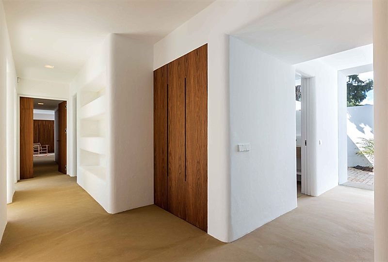 Distribuidor interior con puertas de madera y hornacinas