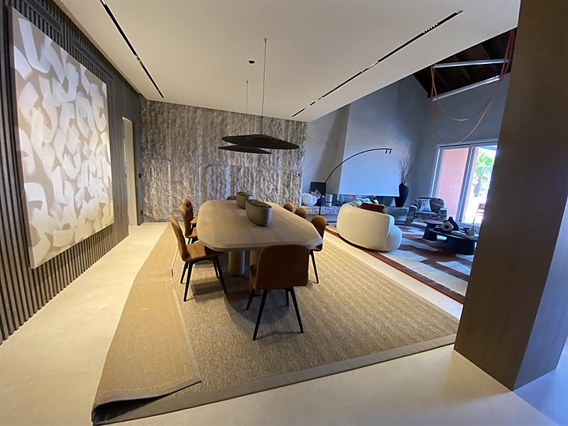 Salón comedor diáfano con panelado de madera e iluminación empotrada