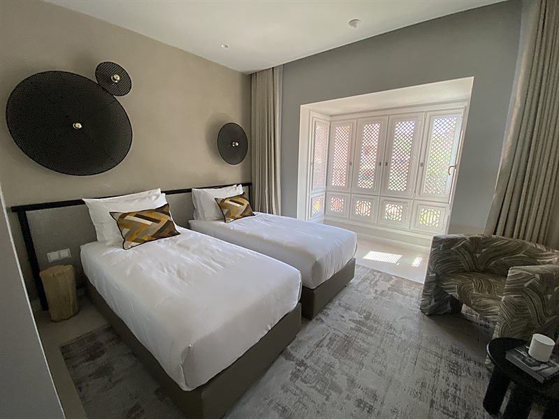 Dormitorio secundario con camas gemelas y ventana con contraventanas de madera